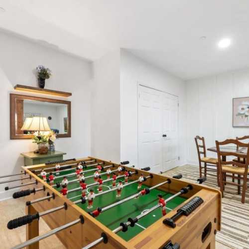 The lower level recreation room has a classic foosball table that takes center stage, perfect for indoor entertainment and friendly competitions.