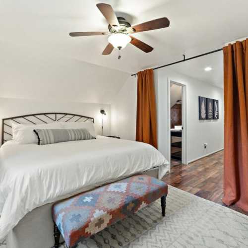 Bedroom 1: King bed is separated from bunk beds by curtains