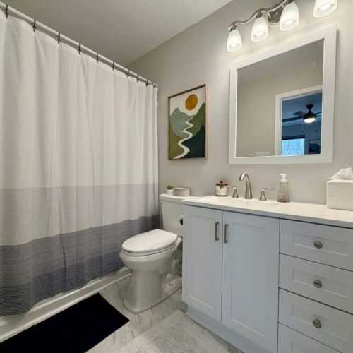 Bathroom 1: full bathroom with bathtub/shower combo; en suite to bedroom 1