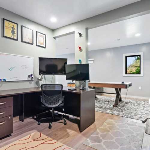 Lower level office area with spacious desk and monitors